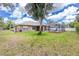 Spacious backyard showcasing the lawn, home, and inviting screened-in pool area at 1247 Nora Ln, North Port, FL 34286