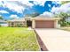 Charming single-story home featuring a well-manicured lawn and a two-car garage at 1247 Nora Ln, North Port, FL 34286
