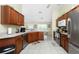 Well-lit kitchen featuring stainless steel appliances, and abundant wood cabinetry at 1247 Nora Ln, North Port, FL 34286