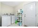 Laundry room featuring a white washer and dryer set with shelves, and a door at 1247 Nora Ln, North Port, FL 34286