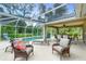 Relaxing screened-in patio featuring comfortable seating, a pool, and lush greenery at 1247 Nora Ln, North Port, FL 34286