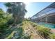 Lush backyard with a screened pool enclosure, offering privacy and a serene outdoor environment at 13080 Proctor Ave, Port Charlotte, FL 33981