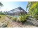 Beautiful backyard featuring a screened pool enclosure and well-maintained landscaping at 13080 Proctor Ave, Port Charlotte, FL 33981