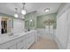 Well-lit bathroom features a double vanity, tiled floors, and a separate area for toilet at 13080 Proctor Ave, Port Charlotte, FL 33981