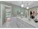 Spacious bathroom with double sinks, tiled floors, and views to the backyard and pool area at 13080 Proctor Ave, Port Charlotte, FL 33981