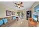 Well-lit room offers a ceiling fan, bookshelves, a futon, and sliding doors to the patio at 13080 Proctor Ave, Port Charlotte, FL 33981