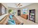 Comfortable room with a ceiling fan, bookshelves, a futon, and sliding doors to the outside at 13080 Proctor Ave, Port Charlotte, FL 33981
