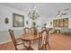 Elegant dining room featuring hardwood floors and an ornate chandelier, adjacent to a spacious living area at 13080 Proctor Ave, Port Charlotte, FL 33981