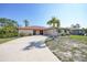 Charming single-story home with a well-manicured lawn, mature palm tree, and a spacious driveway at 13080 Proctor Ave, Port Charlotte, FL 33981