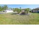 Well-manicured lawn featuring mature palm trees and blooming flower beds, enhancing curb appeal at 13080 Proctor Ave, Port Charlotte, FL 33981