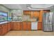 Well-lit kitchen featuring wooden cabinetry, stainless steel appliances, and a neutral backsplash at 13080 Proctor Ave, Port Charlotte, FL 33981