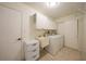 Efficient laundry room with ample storage cabinets, a sink, and modern washer and dryer units at 13080 Proctor Ave, Port Charlotte, FL 33981