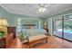 Comfortable main bedroom features a king bed, wood floors, and sliding doors to a private outdoor space at 13080 Proctor Ave, Port Charlotte, FL 33981