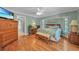 Tranquil main bedroom boasting a king-size bed, wood floors, and ample natural light from multiple windows at 13080 Proctor Ave, Port Charlotte, FL 33981
