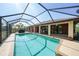 Large screened-in pool with a covered lanai, ideal for enjoying sunny days and outdoor dining at 13080 Proctor Ave, Port Charlotte, FL 33981