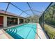 Inviting screened-in pool with clear blue water, adjacent to a covered patio dining area at 13080 Proctor Ave, Port Charlotte, FL 33981