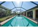Spacious screened-in pool surrounded by lush landscaping, perfect for outdoor activities and gatherings at 13080 Proctor Ave, Port Charlotte, FL 33981