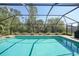 Beautiful backyard pool area with tropical landscaping and a screened enclosure for year-round enjoyment at 13080 Proctor Ave, Port Charlotte, FL 33981