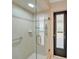 Walk-in shower features stylish tile, grab bars, and a frameless glass enclosure for a modern and accessible design at 13080 Proctor Ave, Port Charlotte, FL 33981