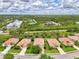 Aerial view of neighborhood with lush, tropical landscaping with pond and homes in the background at 13282 Scrub Jay Ct, Port Charlotte, FL 33953
