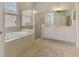 Luxurious bathroom with a soaking tub, glass-enclosed shower, and double vanity sink at 13282 Scrub Jay Ct, Port Charlotte, FL 33953