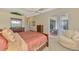 Bright bedroom with sliding doors to screened patio, ceiling fan, chair and dresser at 13282 Scrub Jay Ct, Port Charlotte, FL 33953