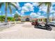 Attractive clubhouse featuring manicured landscaping, multiple palm trees, and convenient golf cart parking at 13282 Scrub Jay Ct, Port Charlotte, FL 33953