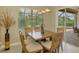 Cozy dining area with natural light, a wooden table, and seating for four by screened patio at 13282 Scrub Jay Ct, Port Charlotte, FL 33953