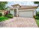 Charming single-story home featuring a brick driveway, two-car garage, and beautifully landscaped front yard at 13282 Scrub Jay Ct, Port Charlotte, FL 33953