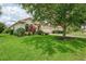 Well-maintained home featuring a two-car garage, lush lawn, and mature landscaping at 13282 Scrub Jay Ct, Port Charlotte, FL 33953