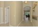 Elegant hallway featuring neutral paint, tile flooring, and arched doorway leading to living areas at 13282 Scrub Jay Ct, Port Charlotte, FL 33953