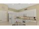 Well-lit kitchen boasts white cabinets, stainless appliances, and ample counter space at 13282 Scrub Jay Ct, Port Charlotte, FL 33953