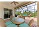Relaxing screened-in patio boasts comfortable seating, an outdoor ceiling fan, and a lovely glass table at 13282 Scrub Jay Ct, Port Charlotte, FL 33953