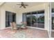 Covered outdoor patio with a dining table, ceiling fan and sliding glass doors to the interior at 13282 Scrub Jay Ct, Port Charlotte, FL 33953