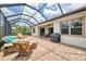 Spacious screened-in patio includes a grill, comfortable seating, and a serene backyard view at 13282 Scrub Jay Ct, Port Charlotte, FL 33953