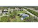 Aerial view of a residential area with a home featuring a screened-in pool and lush landscaping at 13703 Drysdale Ave, Port Charlotte, FL 33981