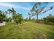 Expansive backyard featuring lush greenery and mature trees, perfect for outdoor activities at 13703 Drysdale Ave, Port Charlotte, FL 33981