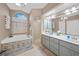 Well-lit bathroom with a tub and shower, double sink, and large vanity at 13703 Drysdale Ave, Port Charlotte, FL 33981