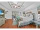 Bright bedroom with a ceiling fan, wood floors, and sliding door access to a balcony at 13703 Drysdale Ave, Port Charlotte, FL 33981