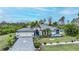 Eye-catching home featuring a manicured lawn, decorative brick driveway, and lovely landscaping at 13703 Drysdale Ave, Port Charlotte, FL 33981