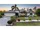 Well-kept home exterior with lush landscaping and palm trees offering curb appeal at 13703 Drysdale Ave, Port Charlotte, FL 33981