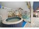 Cozy enclosed patio featuring a hot tub, ceiling fans, and backyard access at 13703 Drysdale Ave, Port Charlotte, FL 33981