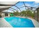 Enclosed pool with brick-paved deck, fun decor, and mature landscaping at 13703 Drysdale Ave, Port Charlotte, FL 33981