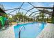 Beautiful screened-in pool featuring lounge chairs and tropical landscaping at 13703 Drysdale Ave, Port Charlotte, FL 33981