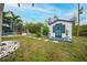 Backyard shed with decorative blue door and window shutters, flanked by potted plants at 13703 Drysdale Ave, Port Charlotte, FL 33981