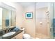 Bathroom with tiled walk-in shower, granite vanity, and decorative artwork at 1375 Beach Rd # 201, Englewood, FL 34223
