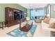 Bright living room with comfortable seating, a TV, and a view of the water and the balcony at 1375 Beach Rd # 201, Englewood, FL 34223