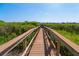Community walkway featuring wood boards and lush foliage surrounding at 1375 Beach Rd # 201, Englewood, FL 34223