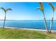 Beautiful waterfront with lush grass, palm trees, and clear blue water at 1375 Beach Rd # 201, Englewood, FL 34223
