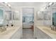 A well-lit bathroom with dual sinks leads to a bedroom with a ceiling fan and a balcony at 1501 Beach Rd # 310, Englewood, FL 34223
